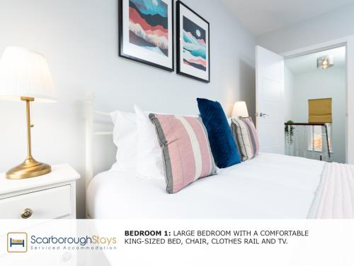 a bedroom with a white bed with pillows on it at Scarborough Stays - Trafalgar Lodge - 4 bedroomed house - Free Parking in Scarborough