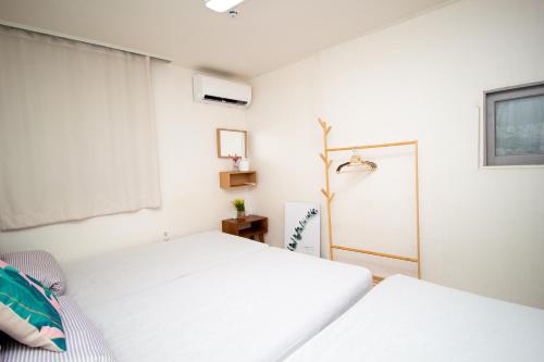 a bedroom with two beds and a window at YAB-GuestHouse, FemaleOnly, ForeignOnly in Seoul