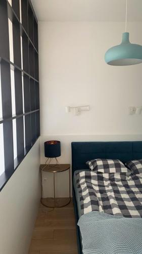 1 dormitorio con 1 cama, 1 silla y 1 lámpara en Apartament z widokiem na morze, en Darłowo
