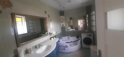 a bathroom with a sink and a toilet and a mirror at Mazurskie Wzgórze Dom Wakacyjny in Rydzewo