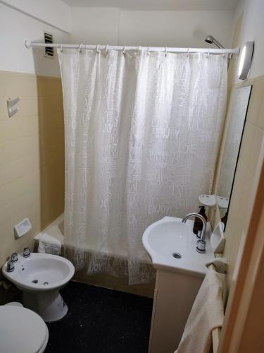 a bathroom with a sink and a toilet and a shower curtain at Studio 7 - Hospital Italiano in Buenos Aires