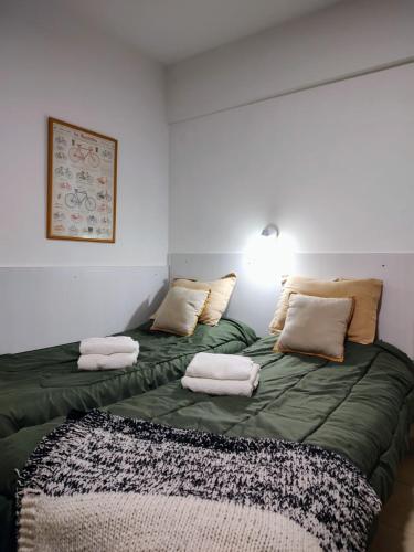 Duas camas num quarto com lençóis e almofadas verdes em Studio 7 - Hospital Italiano em Buenos Aires