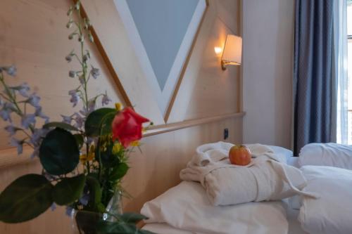 a hotel room with a bed with a towel and a tomato on it at Hotel Italia in Castello di Fiemme