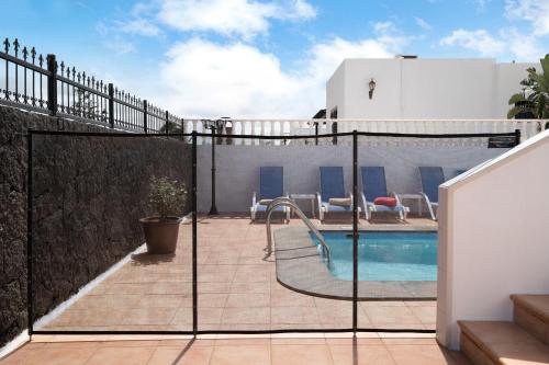 a balcony with a swimming pool and a fence at Villa Carolina in Tías