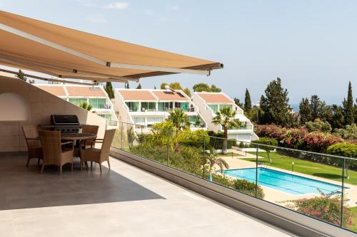 a balcony with a table and chairs and a pool at Bayview Terraces in Limassol