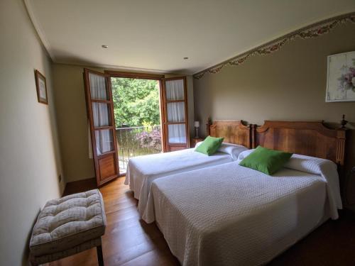 a bedroom with two beds and a window at Apartamentos Mazuga Rural in Po
