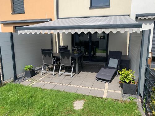 a patio with a table and chairs under a canopy at Ferienhaus Alte Kaserne in Andernach