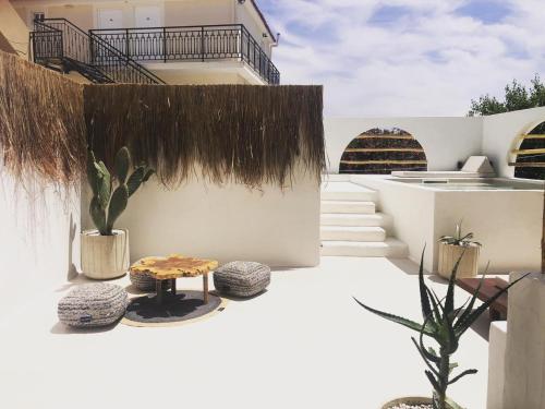 a white building with some plants and a table at GARDELLI RESORT in Laganas