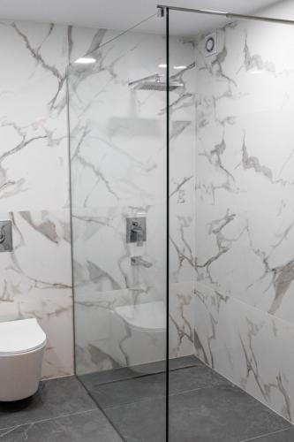 a bathroom with a glass shower with a toilet at Bayview Terraces in Limassol