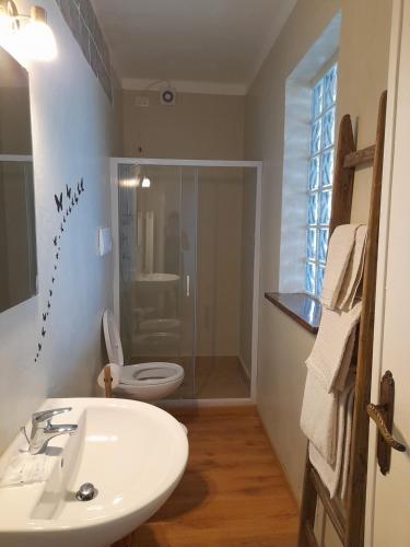 a bathroom with a white sink and a toilet at Casa Vacanze La Mezzaluna in Molini di Triora