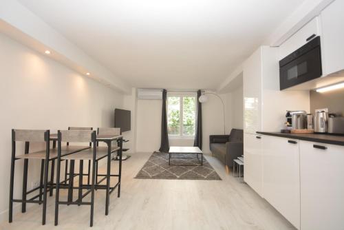 cocina y sala de estar con mesa y sillas en Design 1 BDR with AC en París