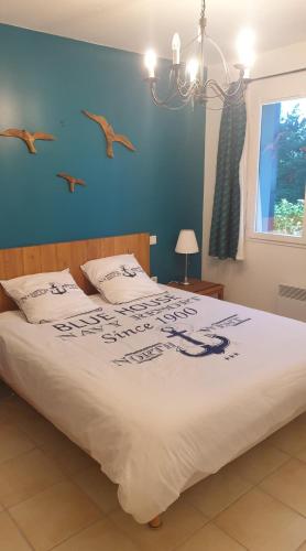 - une chambre dotée d'un grand lit avec des oiseaux sur le mur dans l'établissement Les pins penchés Love Hardelot plage, à Neufchâtel-Hardelot