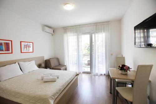 a bedroom with a bed and a table and a desk at House Star in Petrovac na Moru