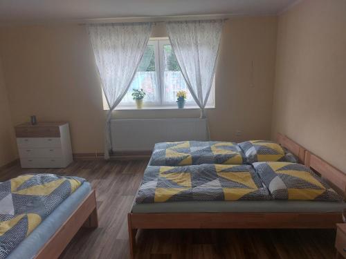 洛西尼的住宿－Apartmány u Mlýna，一间卧室设有两张床和窗户。