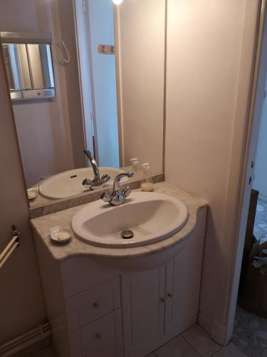 une salle de bain avec un lavabo et un miroir dans l'établissement Saint Clair, à La Baule