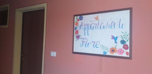 a sign on a pink wall with a sign on it at Appartamento Fiore in Bagnolo Mella