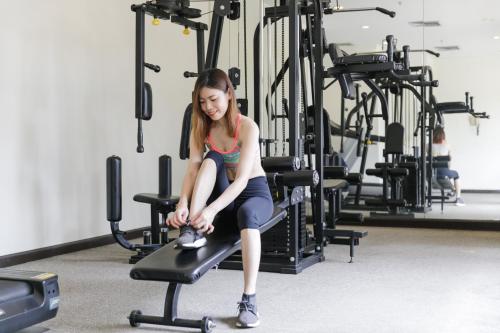 a young girl sitting on a treadmill in a gym at Amora Thapae Hotel Chiang Mai in Chiang Mai