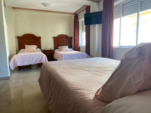 een slaapkamer met 2 bedden en roze kussens bij Hotel Medina Centro in Jerez de la Frontera