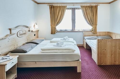two twin beds in a room with a window at Hotel 2000 in Livigno