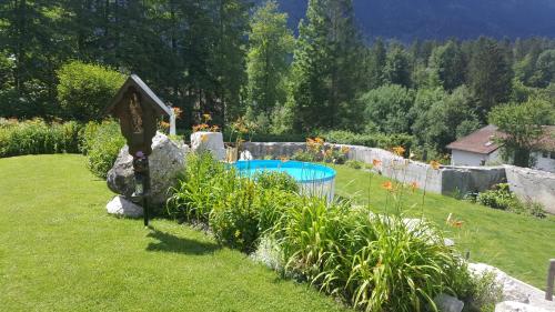 un jardín con piscina en un patio en Alpenchalet Zum Jeremia, en Grainau