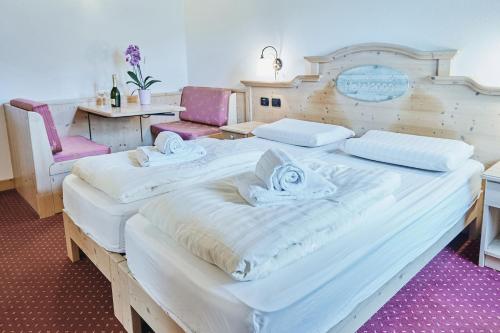 two large beds in a room with two chairs at Hotel 2000 in Livigno