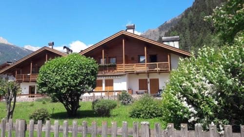 a house with a fence in front of it at Appartamento Bucaneve in Predazzo