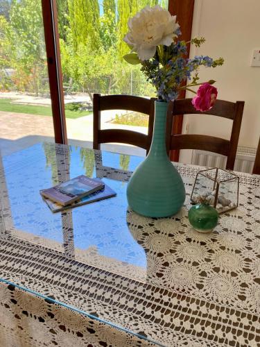 a glass table with a vase and flowers on it at Demelida Villa in Tsada, Paphos in Tsadha