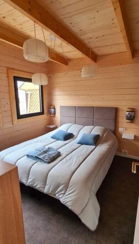 une chambre avec un grand lit dans une pièce en bois dans l'établissement Cabourg Dives Houlgate - Cosy private home, à Dives-sur-Mer