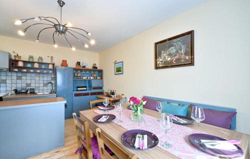 a dining room with a table and a kitchen at HIŽA BAKE ROZE in Gornja Konjšćina
