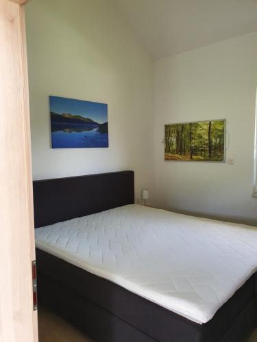 uma cama num quarto com um colchão grande em Ferienhäuser Seetraum em Weissensee