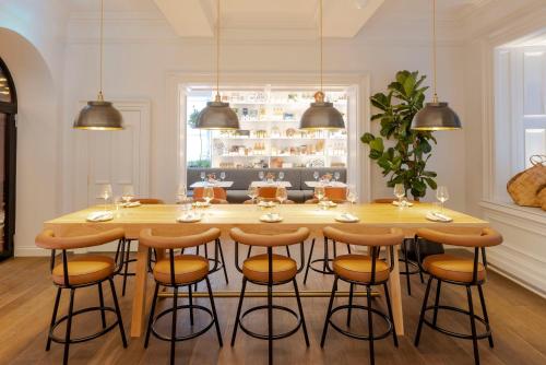 a kitchen with a large wooden table and stools at Virgin Hotels Edinburgh in Edinburgh