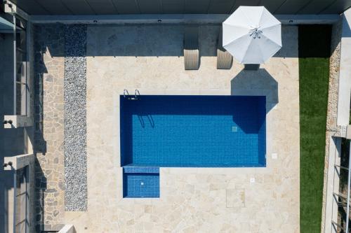 an overhead view of a swimming pool with a white umbrella at Galini House in Tria Monastiria