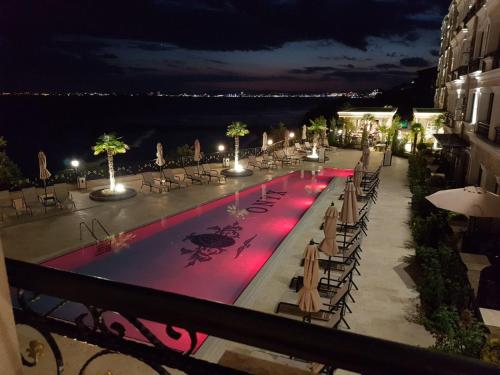 una piscina por la noche con mesas y sillas en ONYX 2 Private Apartment en Sveti Vlas