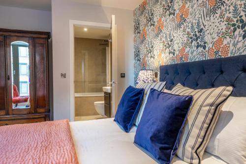 1 dormitorio con 1 cama con almohadas azules en Out of Office @ Ryedale House, en York