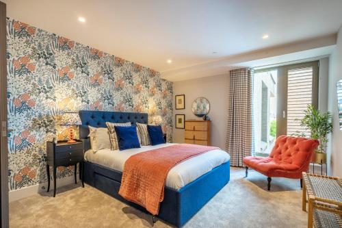 1 dormitorio con 1 cama azul y 1 silla roja en Out of Office @ Ryedale House, en York