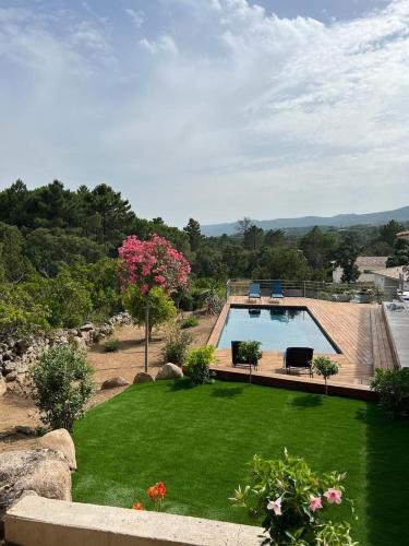 une cour avec une piscine et de l'herbe verte dans l'établissement Villa Monte e Mare, piscine chauffée, climatisée à 5 mn de la plage de santa giulia, à Porto-Vecchio