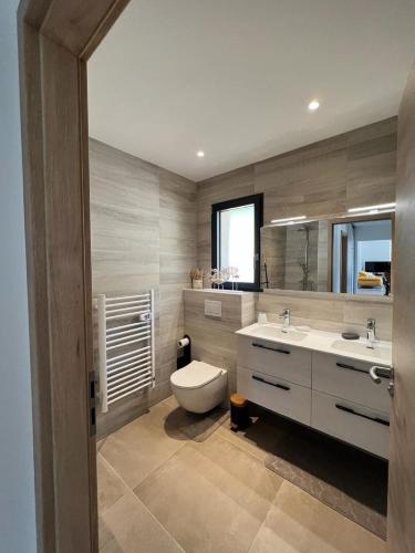 une salle de bain avec toilettes et lavabo dans l'établissement Villa Monte e Mare, piscine chauffée, climatisée à 5 mn de la plage de santa giulia, à Porto-Vecchio