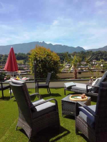 a patio with wicker chairs and tables on the grass at Aix-les-Bains Appart'S in Aix-les-Bains