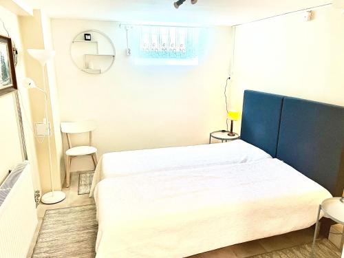 a bedroom with a large white bed with a blue headboard at 3 rooms with private kitchen & private bathroom 5B in Gävle