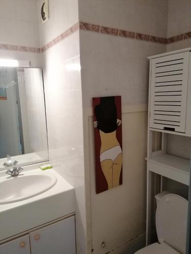 - une salle de bains avec lavabo et peinture d'une femme dans l'établissement LE VALLON, à Pornic
