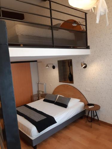 a bedroom with a bunk bed with a white bedspread at Hôtel Des Arts, Artisanal et Indépendant in Montpellier