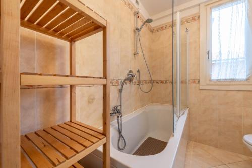 bagno con vasca, doccia e lavandino di Appartamento Rocchetta a Salò