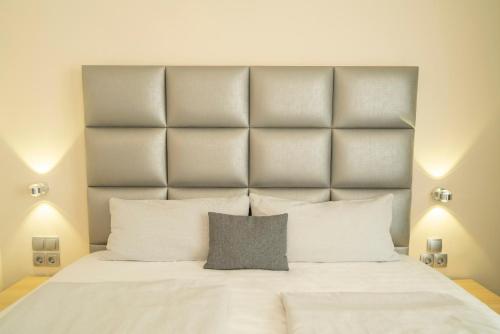 a bedroom with a large white bed with two lights at NP Hotel Königshof in Dortmund