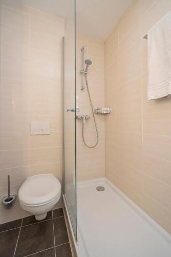 a bathroom with a shower and a toilet and a tub at NP Hotel Königshof in Dortmund