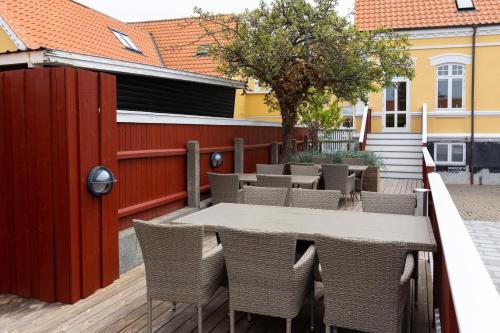 un patio con mesa, sillas y una valla en Ankerhus Skagen, en Skagen