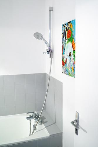 La salle de bains est pourvue d'une douche et d'une peinture murale. dans l'établissement MAMA with aircon including a parking space at 300 meters, à Colmar