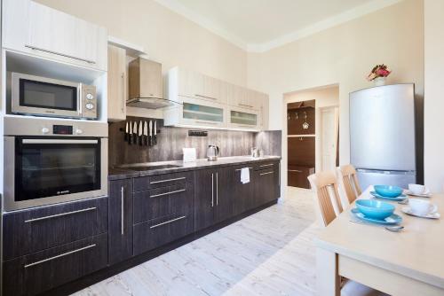 a kitchen with wooden cabinets and a sink and a table at Wellness Penzion U Muzea in Liberec