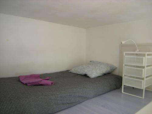 une chambre avec un lit et une étagère blanche dans l'établissement AV GAMBETTA, à Arcachon