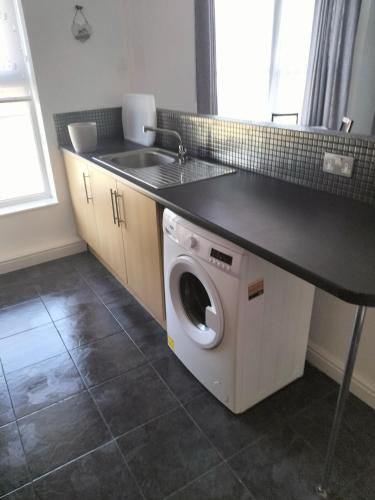 a kitchen with a sink and a washing machine at Place by the sea 2 in Bridlington