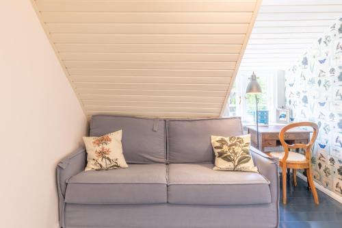 a blue couch in a room with a table at Gabrielswarft in Dagebüll